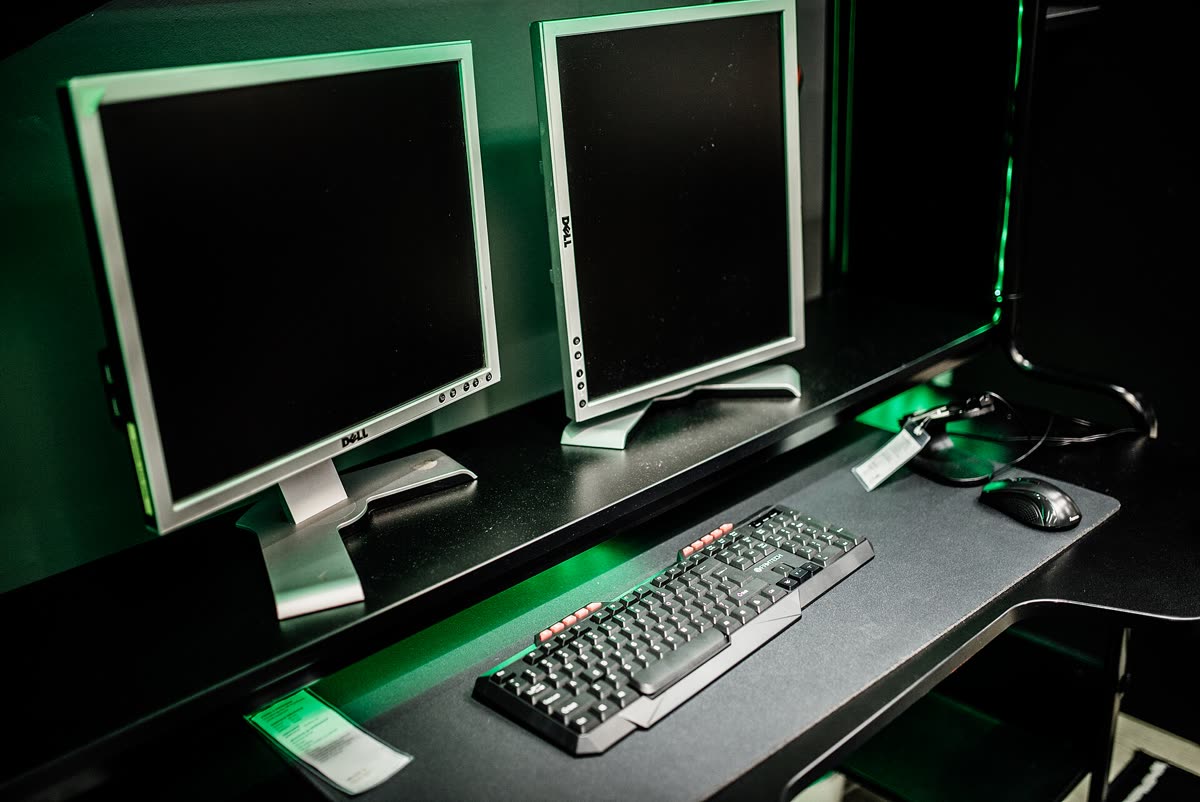 Dual monitor setup in a gaming room with keyboard and mouse in focus — 게이밍 모니터와 TV, 어디까지 나왔나